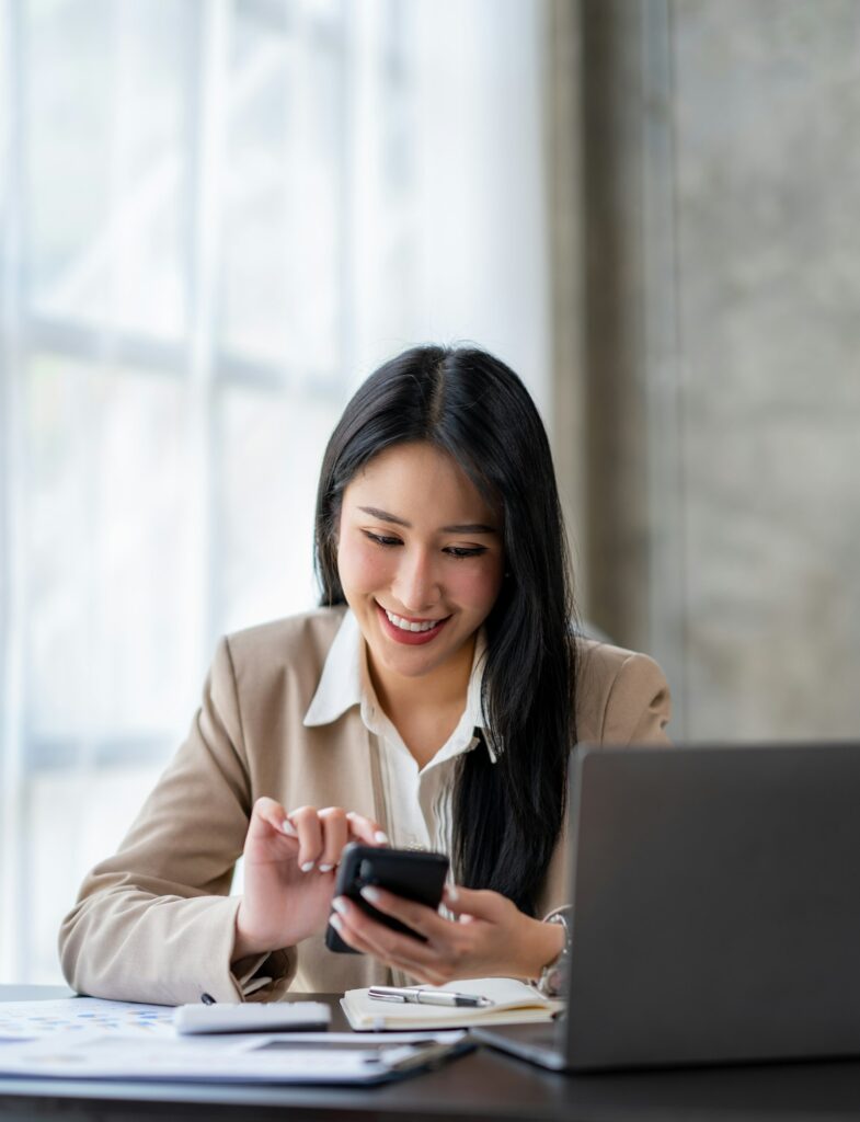 Asian businesswoman holding and dialing the phone to contact customers with financial details Earnin