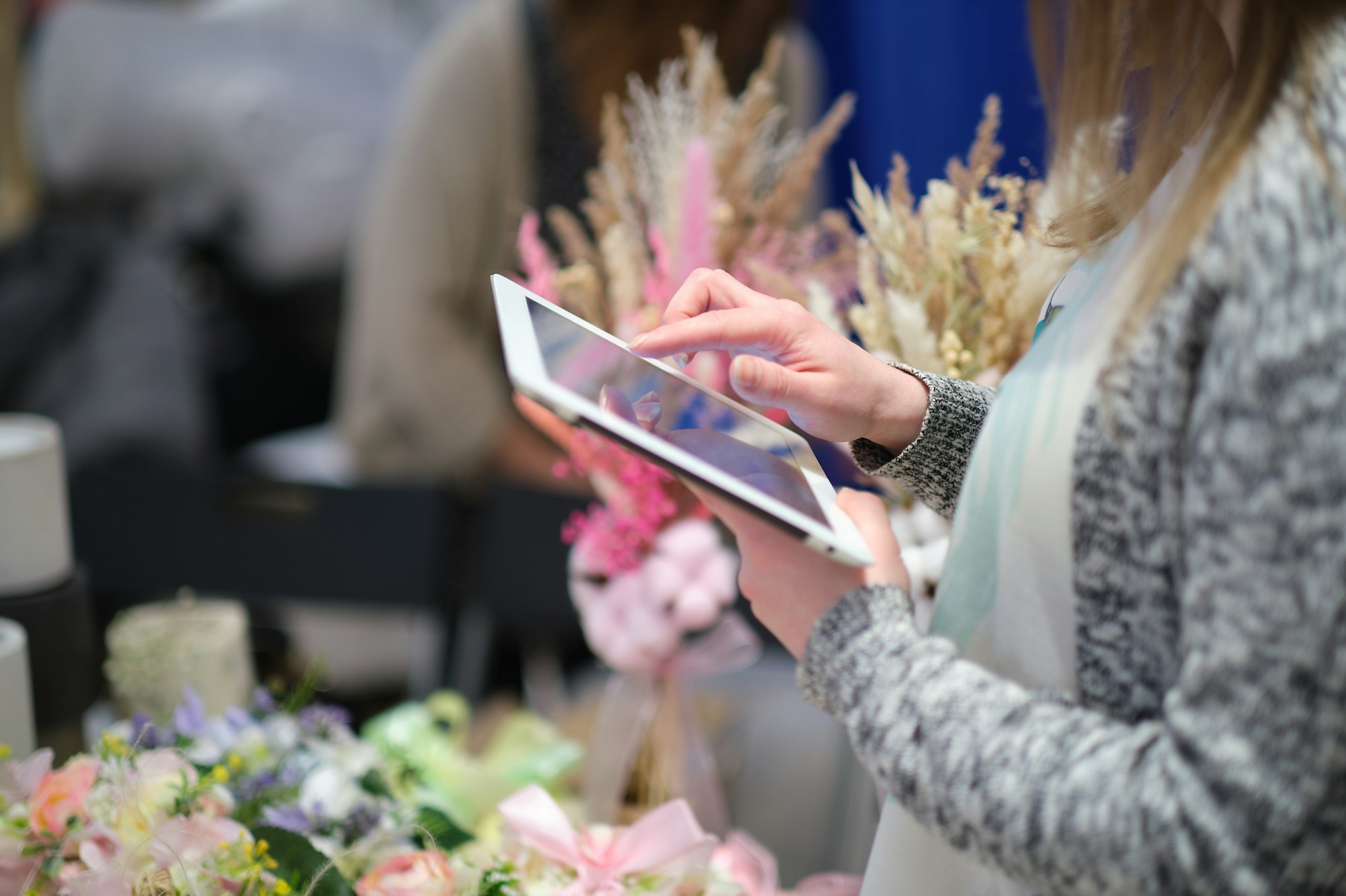 female uses a tablet to advertise their products and communicate with customers.